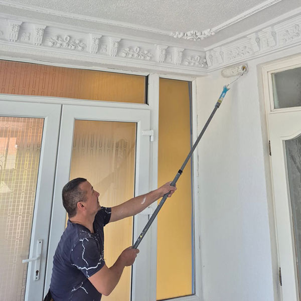 Ein Maler streicht eine Wand